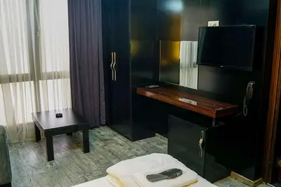 a hotel room with a tv and a bed and a table at Ömer Agah Istanbul Hotel Bayrampasa in Istanbul