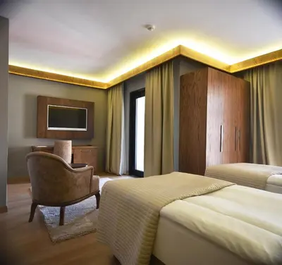 a hotel room with two beds and a chair at The Elegant Hotel in Istanbul