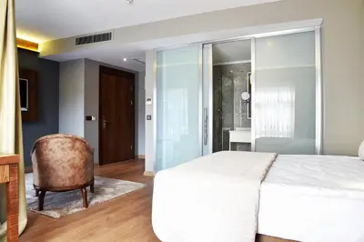 a bedroom with a white bed and a chair at The Elegant Hotel in Istanbul