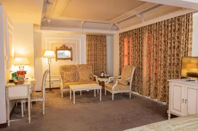 a living room with chairs and a couch and a television at Anemon Koleksiyon Galata Otel in Istanbul