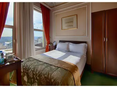 a small bedroom with a bed and a window at Anemon Koleksiyon Galata Otel in Istanbul