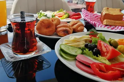 a table with two plates of food and a drink at Sembol Hotel in Istanbul