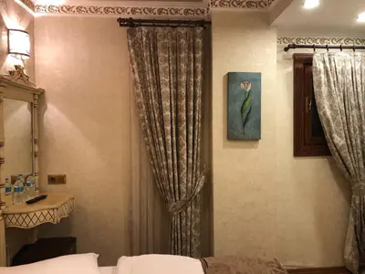 a bedroom with a bed and a window with curtains at Kaftan Hotel in Istanbul