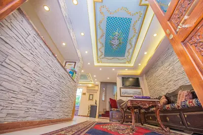 a living room with a ceiling with a painting on it at Kaftan Hotel in Istanbul