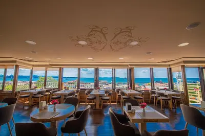 a restaurant with tables and chairs and large windows at Kaftan Hotel in Istanbul