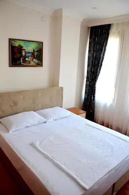 a bedroom with a white bed with a window at Baran Home Aparts in Istanbul
