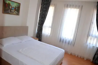a bedroom with a white bed and two windows at Baran Home Aparts in Istanbul