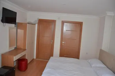 a bedroom with a bed and two wooden doors at Baran Home Aparts in Istanbul