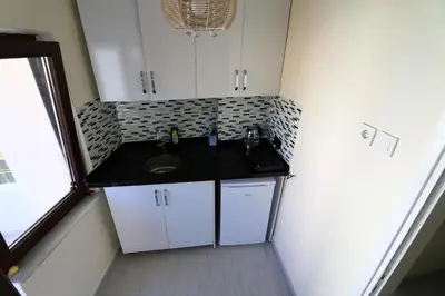 a small kitchen with a sink and white cabinets at Oldtown Sultanahmet Suites in Istanbul