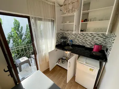 a small kitchen with white cabinets and a balcony at Oldtown Sultanahmet Suites in Istanbul