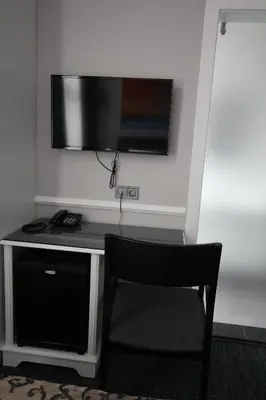 a desk with a television on a wall with a chair at Hotel Naumpasa Konagi in Istanbul