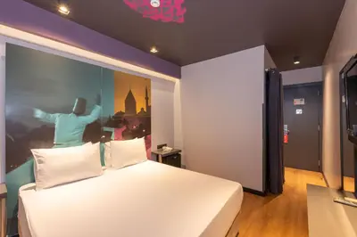 a bedroom with a white bed with a painting on the wall at Tulip City Hotel & Spa in Istanbul