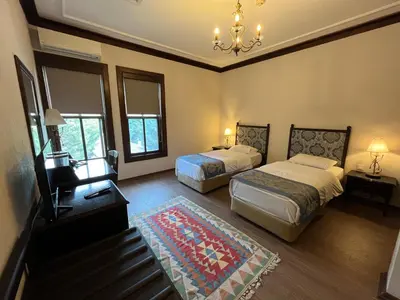 a bedroom with two beds and a chandelier at Otantik Hotel & Spa in Bursa