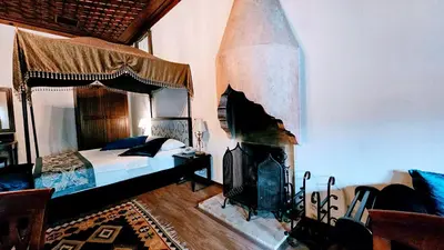 a bedroom with a canopy bed and a fireplace at Otantik Hotel & Spa in Bursa