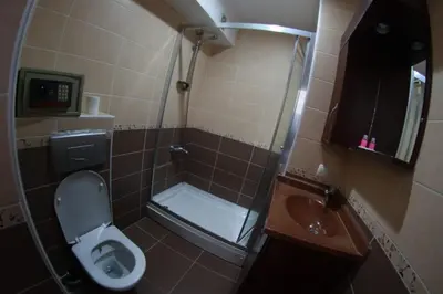 a bathroom with a shower and a toilet and a sink at Ares Hotel in Istanbul