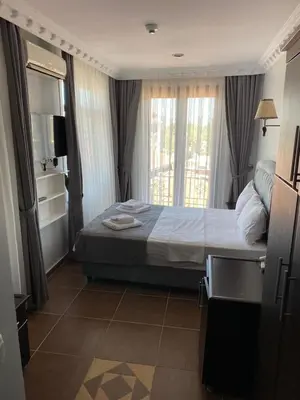 a bedroom with a bed and a tv and a window at Ares Hotel in Istanbul