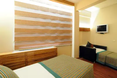 a hotel room with a window with a bed and a chair at Hotel Buyuk Keban in Istanbul