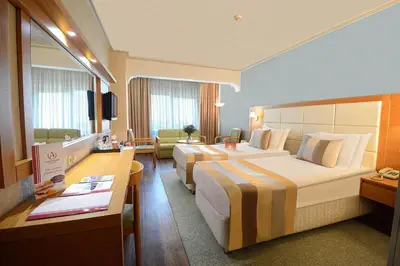 a hotel room with two beds and a desk at Akgun Istanbul Hotel, WorldHotels Elite in Istanbul