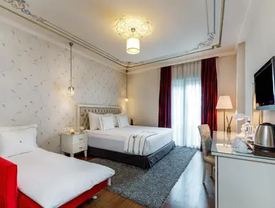 a hotel room with two beds and a television at Hotel Amira Istanbul in Istanbul