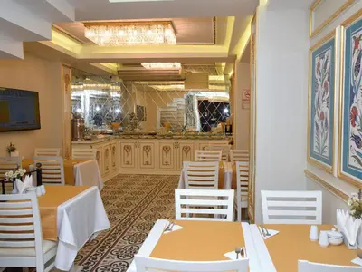 a restaurant with tables and white chairs and a counter at Best Town Hotel in Istanbul