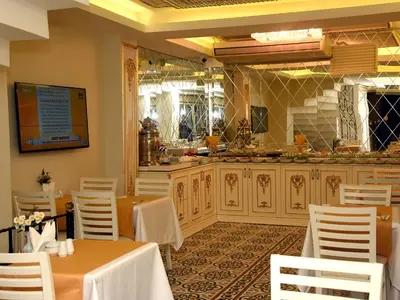 a restaurant with a table and chairs and a kitchen at Best Town Hotel in Istanbul