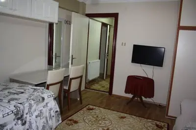 a bedroom with a bed and a table and a television at Bandirma Saglik Apart in Bandırma