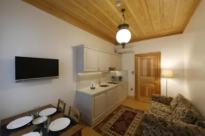 a room with a kitchen with a table and a tv at Catirga Konak Apartments in Istanbul