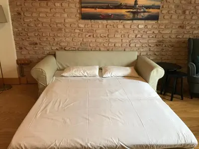 a white couch in a room with a brick wall at Catirga Konak Apartments in Istanbul