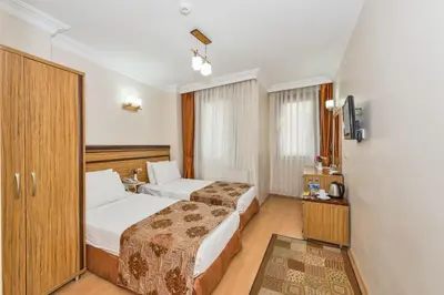 a hotel room with two beds and a television at May Hotel Istanbul in Istanbul