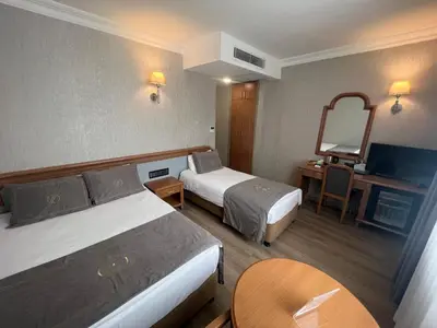 a hotel room with two beds and a table at Fuar Hotel in Istanbul