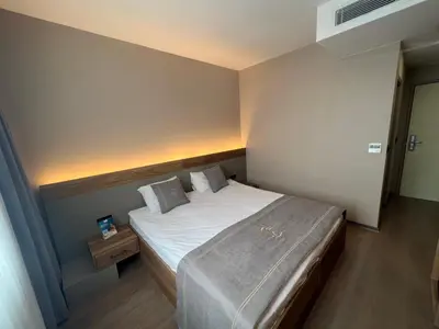 a small bedroom with a bed with white sheets and pillows at Fuar Hotel in Istanbul