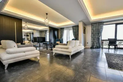 a living room with two white couches and a piano at Heybeli Hotel in Mudanya