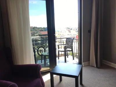 a room with a balcony with a chair and a table at Heybeli Hotel in Mudanya