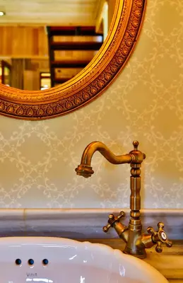 a bathroom sink with a faucet and a mirror at Tranquilla River Lodge in Agva