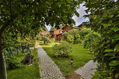 a garden with a cobblestone path in front of a house at Tranquilla River Lodge in Agva