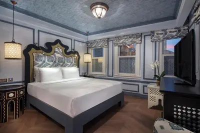 a bedroom with a king sized bed and a television at Hagia Sofia Mansions Istanbul, Curio Collection by Hilton in Istanbul