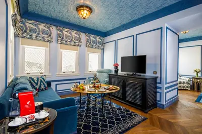a living room with a couch and a tv at Hagia Sofia Mansions Istanbul, Curio Collection by Hilton in Istanbul