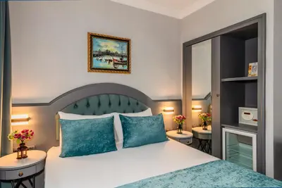 a bedroom with a large bed with blue pillows at Tilia Hotel in Istanbul