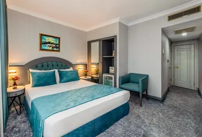 a hotel room with a bed and a blue chair at Tilia Hotel in Istanbul