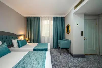 a hotel room with a bed and a blue chair at Tilia Hotel in Istanbul
