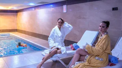 two women sitting in chairs next to a swimming pool at İstanbul Trend Hotel Old City in Istanbul