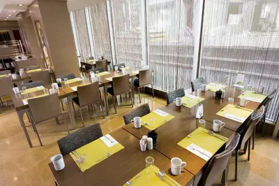 a dining room with tables and chairs and windows at Avantgarde Urban Levent in Istanbul