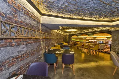 a restaurant with tables and chairs against a brick wall at The Empress Theodora Hotel in Istanbul