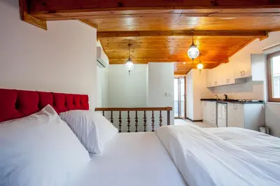 a bedroom with a large white bed with a red headboard at Taksim Sem House in Istanbul