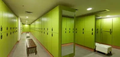 a locker room with green lockers and a wooden bench at The Green Park Pendik in Istanbul