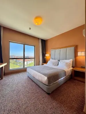 a bedroom with a large bed and a large window at The Green Park Pendik in Istanbul