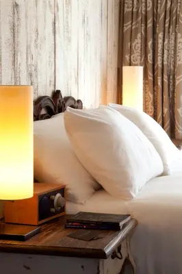 a bed with white pillows and a nightstand with a table with a lamp at Hypnos Design Hotel in Istanbul