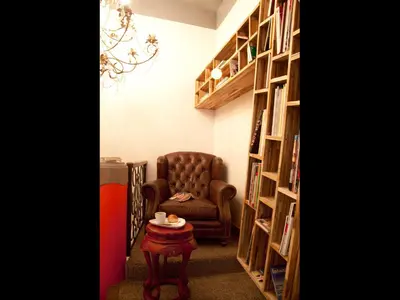 a living room with a chair and a table and bookshelves at Hypnos Design Hotel in Istanbul