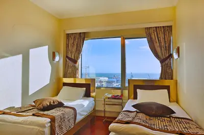 a bedroom with two beds and a large window at Grand Madrid Hotel in Istanbul