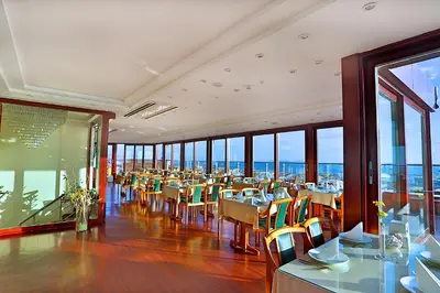 a dining room with tables and chairs and windows at Grand Madrid Hotel in Istanbul